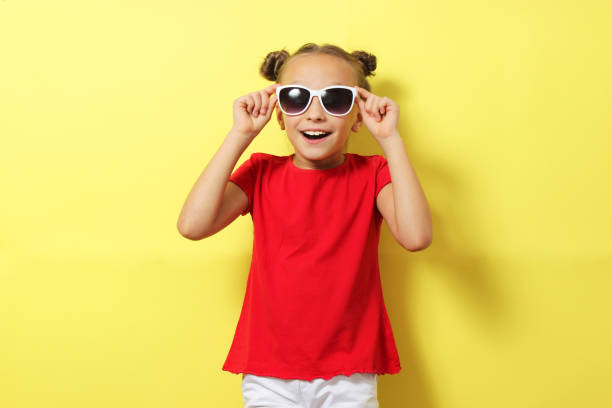 Little cheerful smiling girl in fashionable clothes on a colored background. Children's clothing, children's fashion. High quality photo